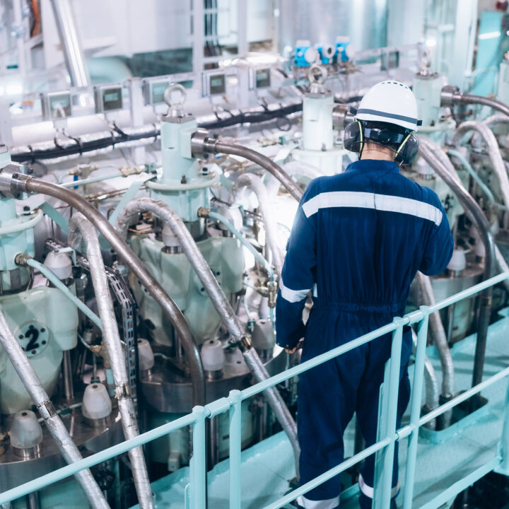 Marine engineer conducting a safety inspection of the ship's main engine.